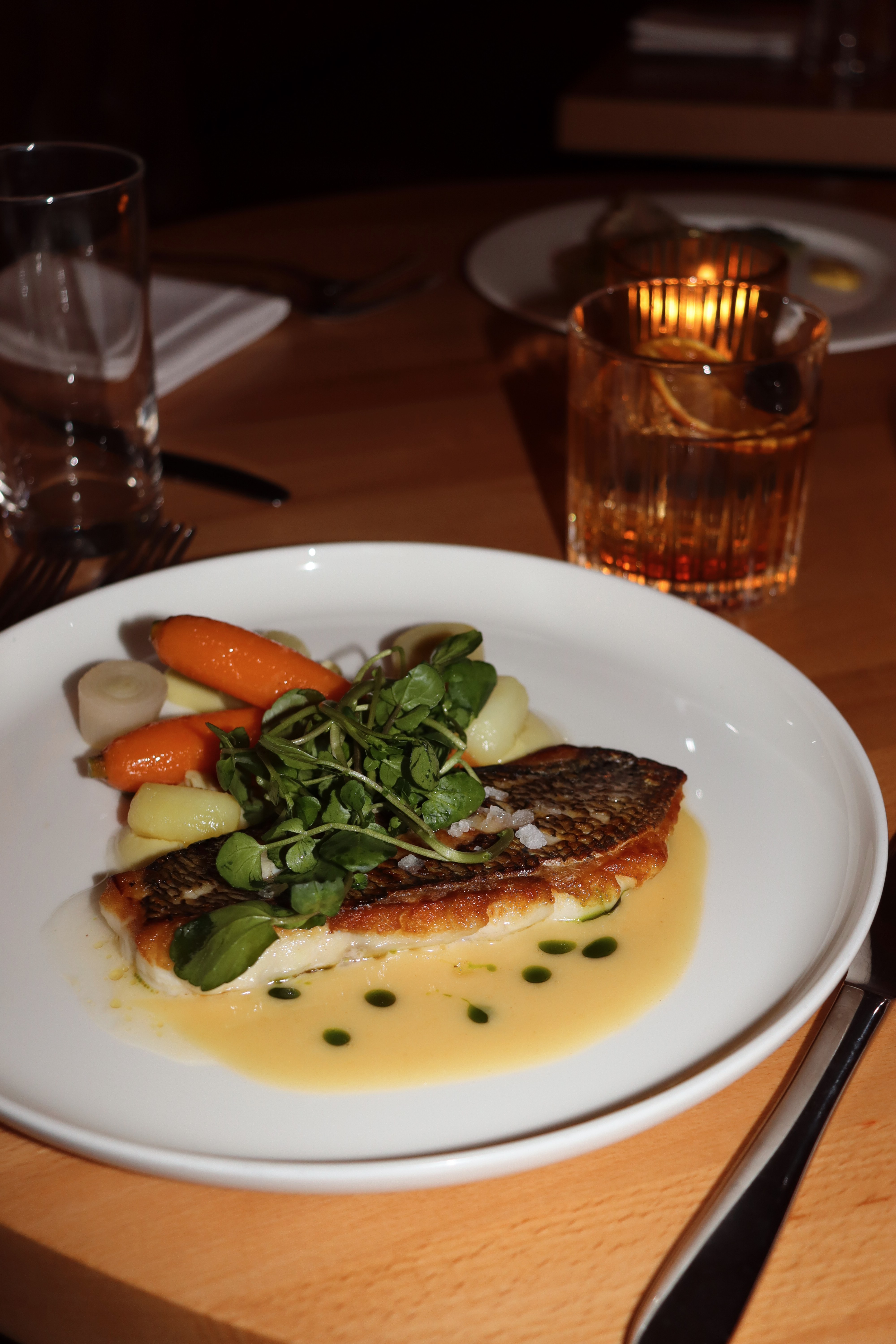 Pan-seared fish with seasonal vegetables by candlelight