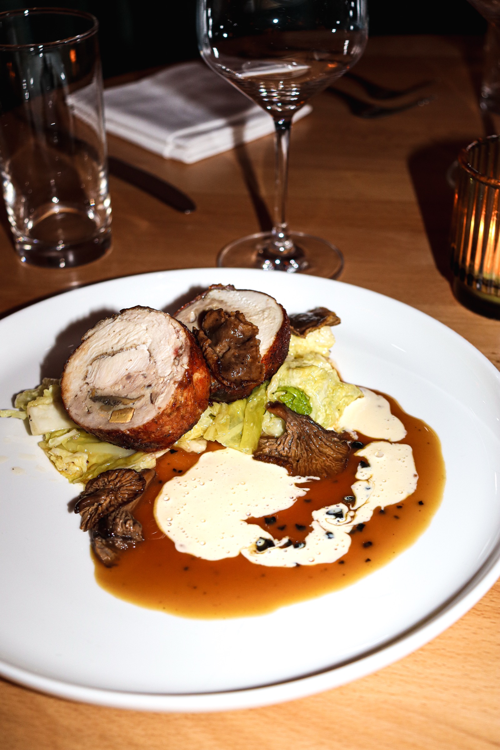 A plated main with mushrooms and jus on the evening table